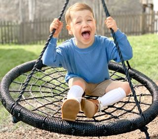 Heart Hero Finn Blumenthal laughing on a swing