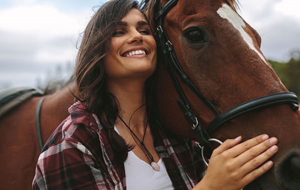 smiling woman hugs horse smiling woman hugs horse