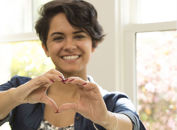 smiling Woman making heart hand gesture smiling Woman making heart hand gesture