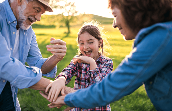 Grandparents and their granddaughter in a field