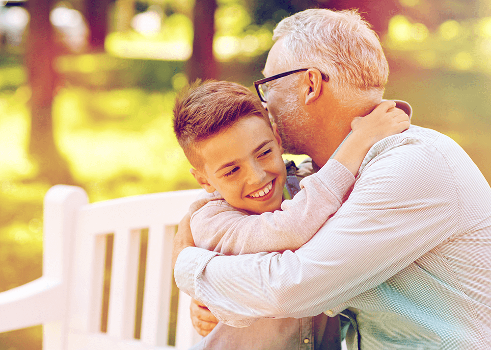 grandfather and grandson hugging at park