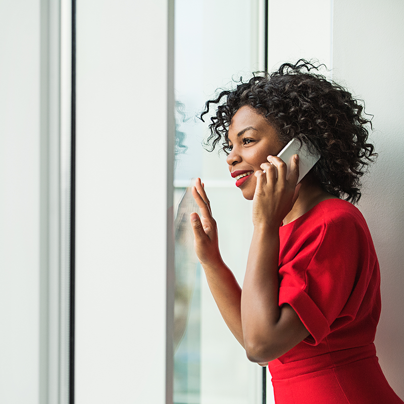 Woman with smartphone standing by window