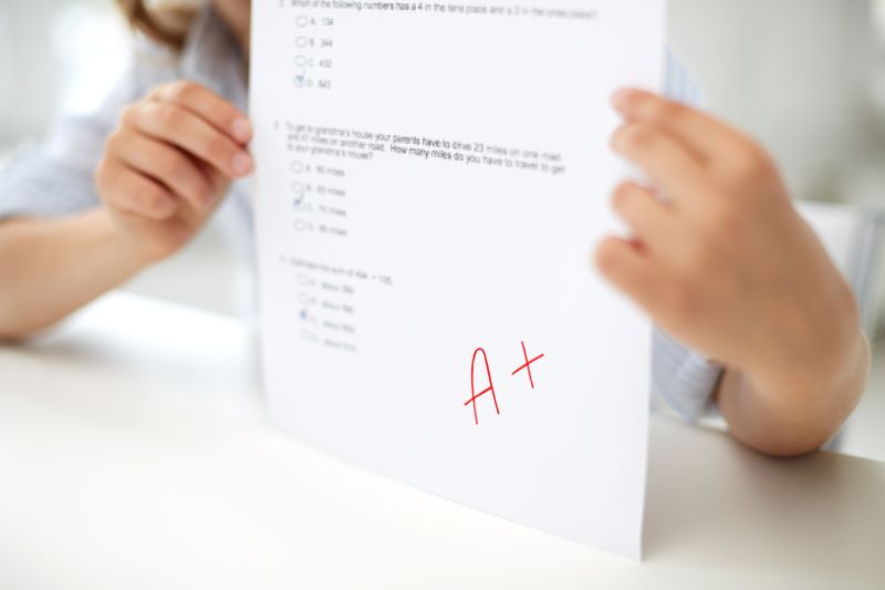 Girl holding a A+ paper up