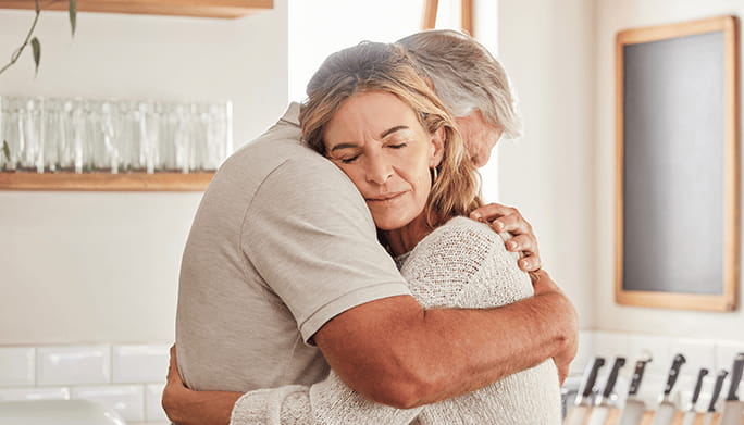 Husband and wife embracing in the kitchen