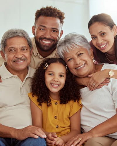A multigenerational family is posing on a sofa.
