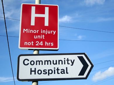 Community Hospital and Minor Injury Unit road signs with a blue sky background Community Hospital and Minor Injury Unit road signs with a blue sky background