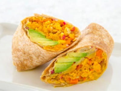 A tuna wrap with avocado is sliced in half and arranged on a plate. A tuna wrap with avocado is sliced in half and arranged on a plate.