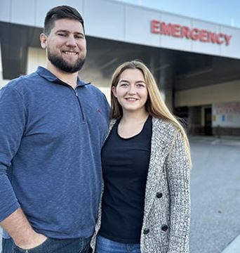 Whitney Sheffield and her husband are standing in front of Brigham City Community Hospital's emergency entrance (photo credit: HCA Healthcare)