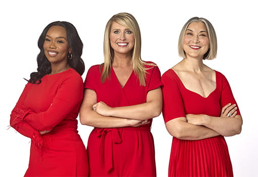 Three women from the Go Red for Women 2025 Class of Survivors posing in red dresses.