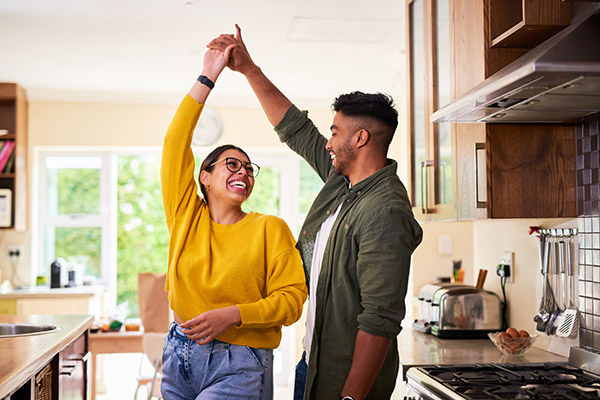 Una pareja joven bailando juntos en la cocina