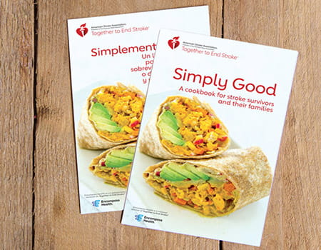 Los libros de cocina “Simply Good” y “Simplemente bueno” se superponen sobre tablas de madera.