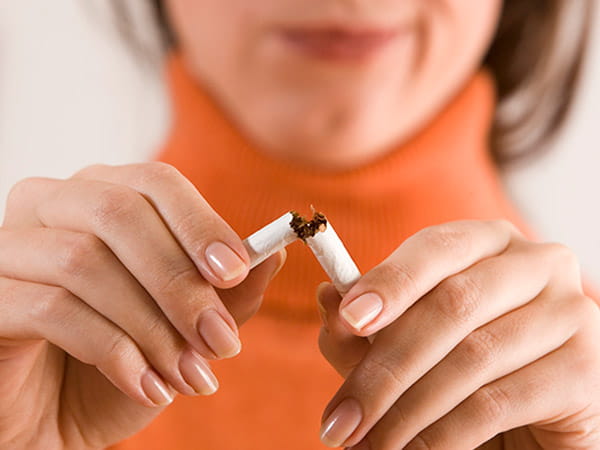 A close-up of a woman breaking a cigarette.